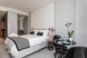 - une chambre avec un lit et une table avec des chaises dans l'établissement Unhotel - Rio Exclusive Design Loft Copacabana Perto da Praia, à Rio de Janeiro