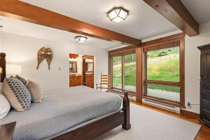 a bedroom with a bed and a large window at Enclave 108, Snowmass Ski-In Ski-Out Condo with Shared Pool, Hot Tub & Gym in Snowmass Village +18 photos