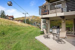a patio with two chairs and a table with a printer at Enclave 108, Snowmass Ski-In Ski-Out Condo with Shared Pool, Hot Tub & Gym in Snowmass Village