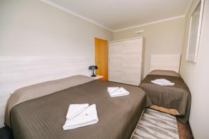 een slaapkamer met 2 bedden en handdoeken bij Spirit Harrachov Superior Wellness Apartments - FREE Wellness, Wifi, Parking, Harrachov Card in Harrachov