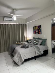 a bedroom with a large bed and a ceiling fan at APTO 1225B Fantástico in Ribeirão Preto