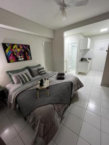 a bedroom with a large bed with a table on it at APTO 1225B Fantástico in Ribeirão Preto +29 photos