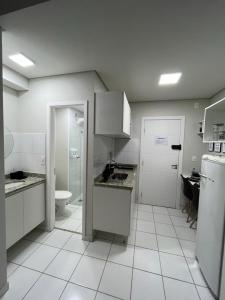 a white kitchen with a sink and a toilet at APTO 1225B Fantástico in Ribeirão Preto