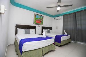 Dos camas en una habitación de hotel con dos en Pa´Xa Mama Hotel Boutique, en Cancún