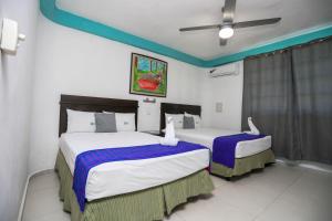 two beds in a hotel room with two at Pa´Xa Mama Hotel Boutique in Cancún