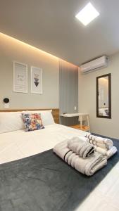 MacambiraIM Suites的卧室配有一张带毯子的大型白色床