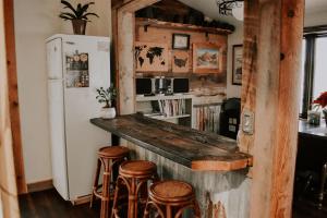 a kitchen with a bar with stools and a refrigerator at Rustic Ranch Getaway Near Zion, Bryce, Grand Canyon in Fredonia