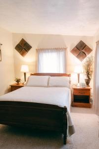 um quarto com uma cama grande, 2 mesas de cabeceira e 2 candeeiros. em The Wolf Manor em Ellinwood