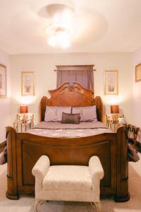 a bedroom with a large wooden bed with a chair at The Wolf Manor in Ellinwood