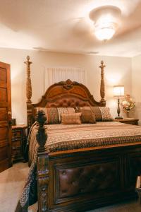 a bedroom with a large bed with a wooden headboard at The Wolf Manor in Ellinwood