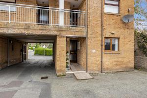 a brick building with a garage and a balcony at Central Apartment 3B in Newcastle