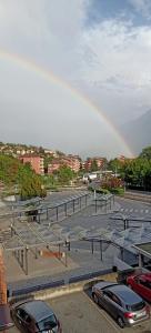 un estacionamiento con coches y un arco iris en el cielo en Casa relax, en Aosta