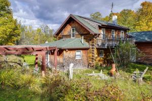 uma casa de madeira com um alpendre e uma varanda em Cozy Cabin in West Chazy with Lake Champlain View! 