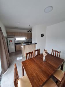 Una cocina y un comedor con mesa y sillas de madera. en CALA DEPARTAMENTO, en Alta Gracia