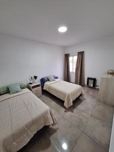 Un dormitorio con dos camas y una ventana. en CALA DEPARTAMENTO, en Alta Gracia