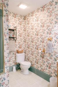 uma casa de banho com WC e papel de parede floral em The Wolf Manor em Ellinwood