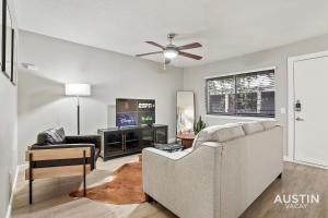 Una sala de estar con un sofá y un televisor en Amenity Heavy Serene Apt in Convenient Location, en Austin