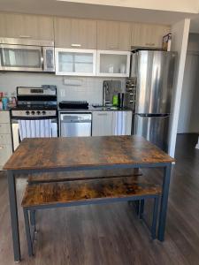 a kitchen with a wooden table and a stainless steel refrigerator at Condo Room for rent in Toronto