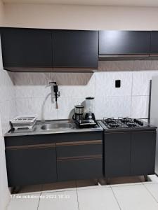 uma cozinha com uma placa de fogão e um lavatório em Bruno Flat Orla da cidade em Petrolina