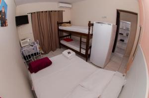 a small room with a bed and a refrigerator at Pousada Esperança in Penha