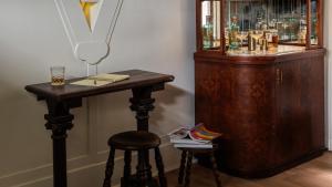 a table and a stool next to a drink cabinet at La Playa Hotel in Carmel