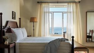 a bedroom with a bed with a view of the ocean at La Playa Hotel in Carmel