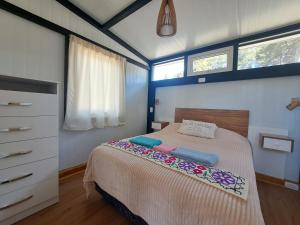 um quarto com uma cama com duas almofadas em Casa Amancay em San Carlos de Bariloche