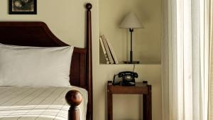 a bedroom with a bed and a telephone on a table at La Playa Hotel in Carmel