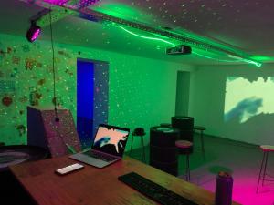 un ordenador portátil sobre una mesa en una habitación con luces verdes en MiBAQ Palermo, en Buenos Aires