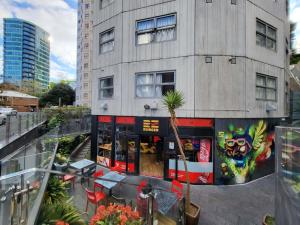 um restaurante com mesas e cadeiras em frente a um edifício em Empire Apartments em Auckland