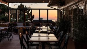 a restaurant with tables and chairs with the sunset in the background at La Playa Hotel in Carmel