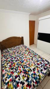 a bed with a colorful comforter in a bedroom at Ap Confort Premium in Campinas