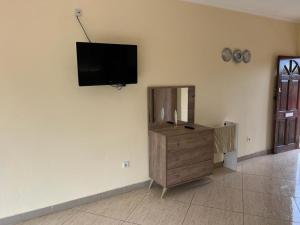 een woonkamer met een flatscreen-tv aan de muur bij Guesthouse Celeste in São Tomé