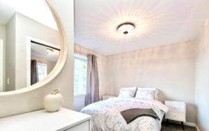 1 dormitorio con cama y espejo en STUNNING HOME WITH AMAZING VIEWS NEAR THE CITY, en Victoria