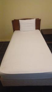 كريستال الشرقية في الخبر: سرير أبيض مع اللوح الخشبي والوسادة البيضاء