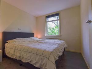 ein Schlafzimmer mit einem Bett und einem Fenster in der Unterkunft De IJsvogel in Heiloo