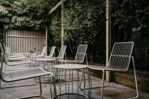 una fila de sillas y mesas blancas en un patio en The Amalfi Minimalist Room 601, en Hepburn Springs