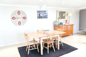 stół w jadalni z krzesłami i zegarem na ścianie w obiekcie Elegant Apartment in Levada Grande + Terrace + 120 m² w mieście Lanceiros