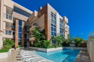 un edificio de apartamentos con piscina y tumbonas en Aracari 1, en Palm-Eagle Beach