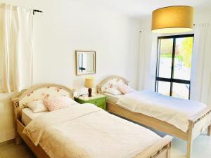 twee bedden in een kamer met een raam bij 3 bedrooms house at Carvoeiro 650 m away from the beach with shared pool furnished garden and wifi in Carvoeiro