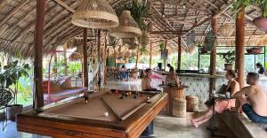 a pool table in a resort with people playing pool at the SPACE. in San Juan del Sur