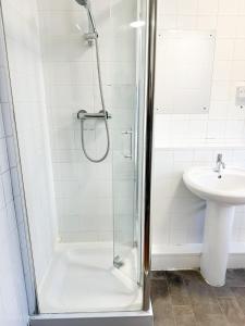 ein Bad mit einer Dusche und einem Waschbecken in der Unterkunft 264 rooms in London