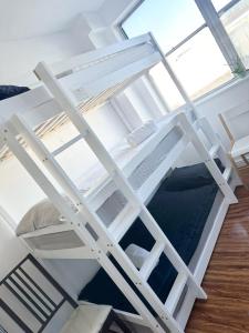 ein weißes Etagenbett in einem Zimmer mit Fenster in der Unterkunft 264 rooms in London