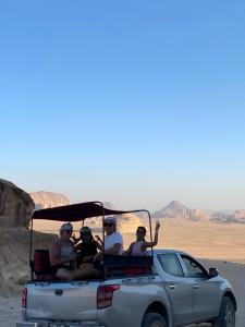 a group of people riding in the back of a truck at Yellow Star Camp Wadi Rum in Wadi Rum