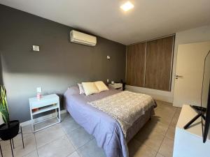 - une chambre avec un lit et une table de chevet dans l'établissement Las Cañas, à Guaymallen