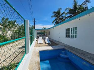 a house with a swimming pool next to a fence at La Casita de Chelem in Chelem