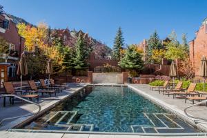 a swimming pool with chairs and a fountain at Luxury 2 Bedroom Aspen Mountain Residence 23 in Downtown one block to Ski Lifts in Aspen