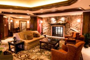 a living room with a couch and a stone fireplace at Luxury 2 Bedroom Aspen Mountain Residence 23 in Downtown one block to Ski Lifts in Aspen