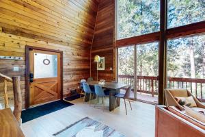 a dining room in a log cabin with a table and chairs at Modern Pines Hideaway in Crestline