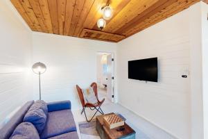 a living room with a couch and a tv at Modern Pines Hideaway in Crestline